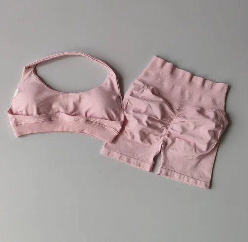 Pink sports bra and shorts set on a gray background